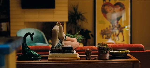 Zendaya: close view of bare soles resting on books.