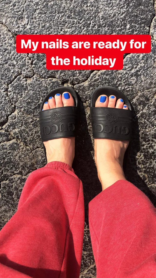 Brec Bassinger shown from above wearing red trousers and black slides.