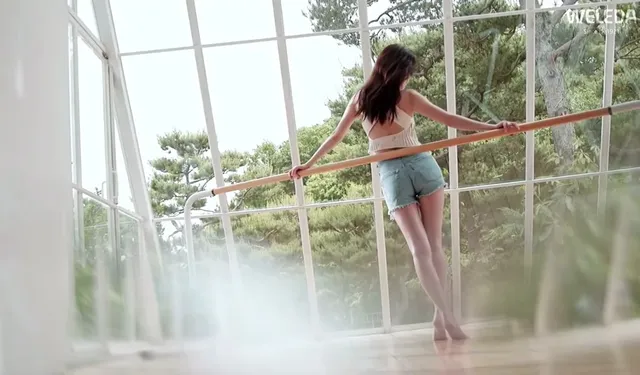 Han So-hee standing barefoot by a ballet barre.