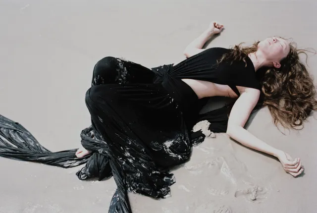 Havana Rose Liu reclining in a dark gown.