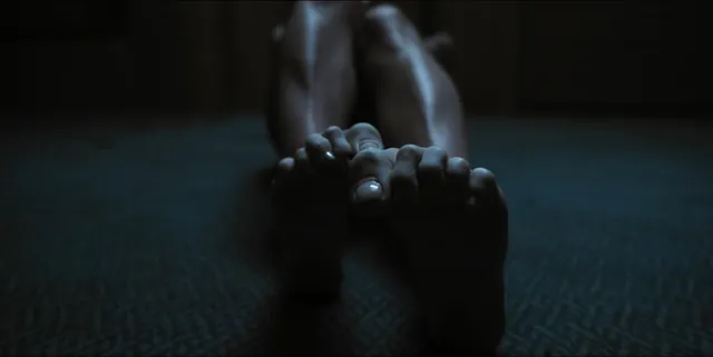 Alice Eve lying on a carpet in a dramatic screen scene.