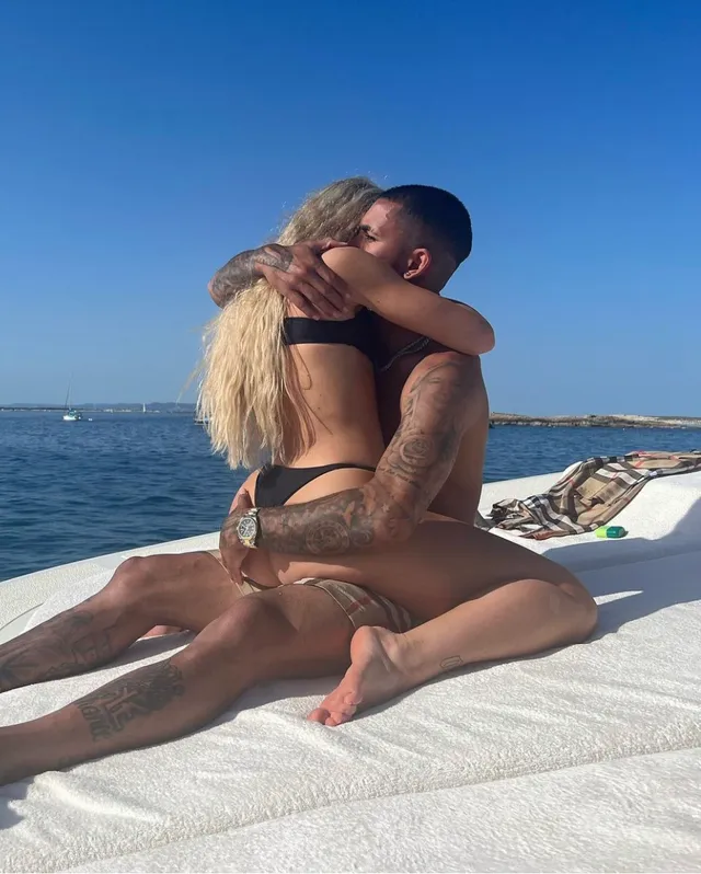 Alisha Lehmann sitting barefoot beside a companion on a boat lounger.