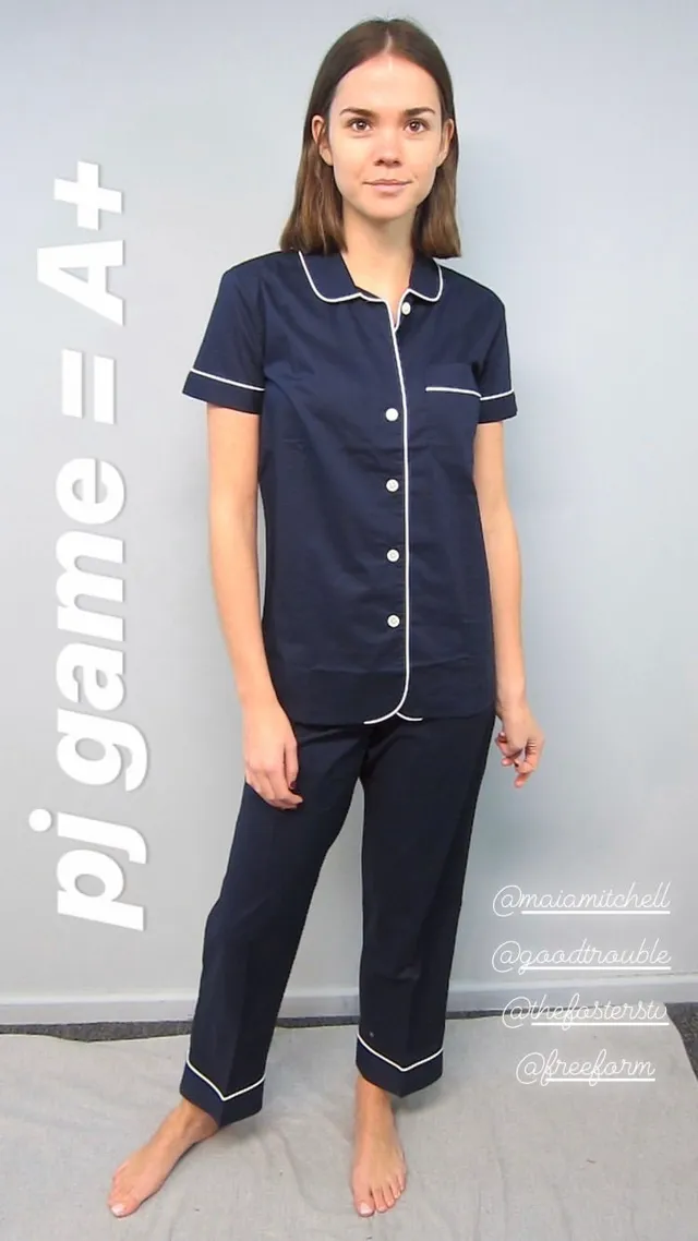 Maia Mitchell standing barefoot in navy pajamas.