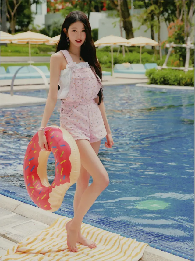 Jang Wonyoung standing barefoot beside a swimming pool.