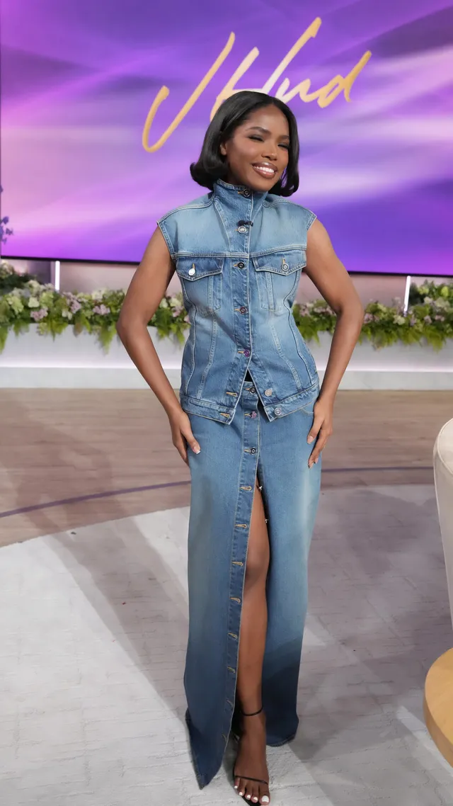 Ryan Destiny wearing a denim dress and heels on a talk show set.