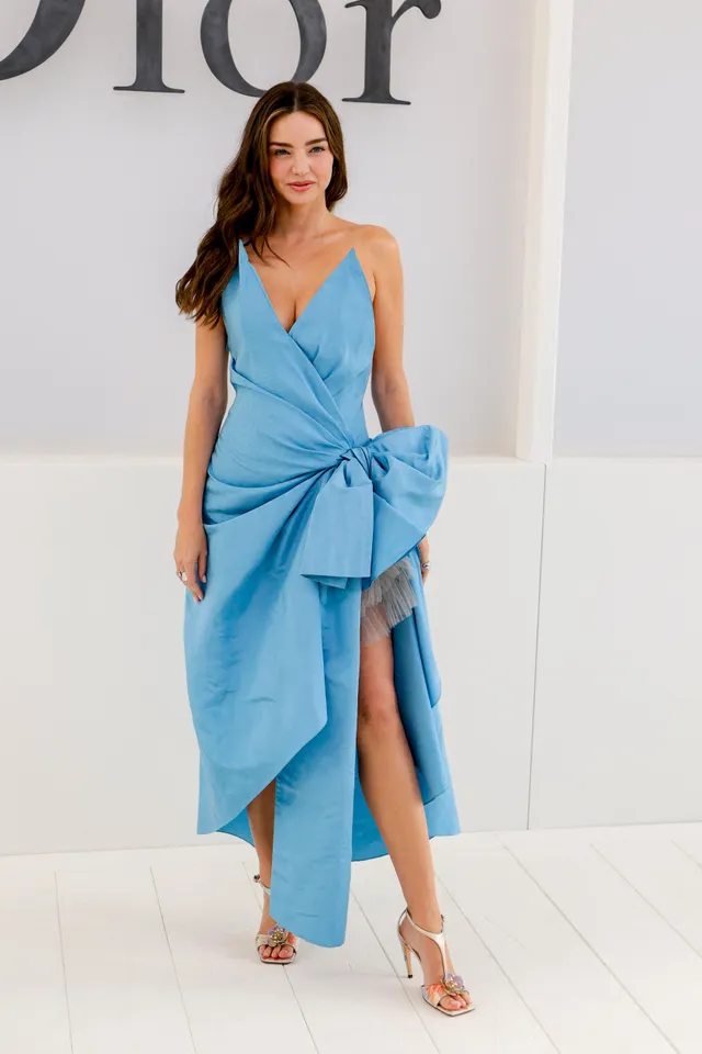 Miranda Kerr a blue dress and pale heels at a fashion event.