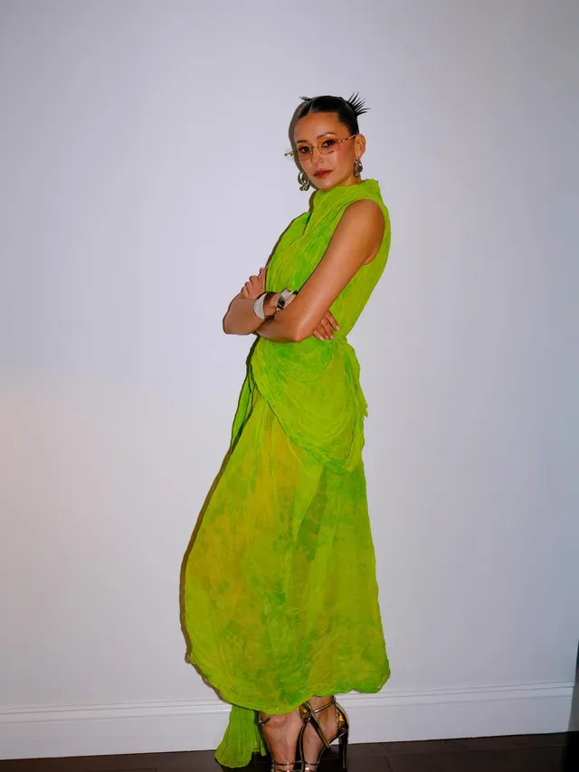 Nina Dobrev wearing a bright green dress and black heels.