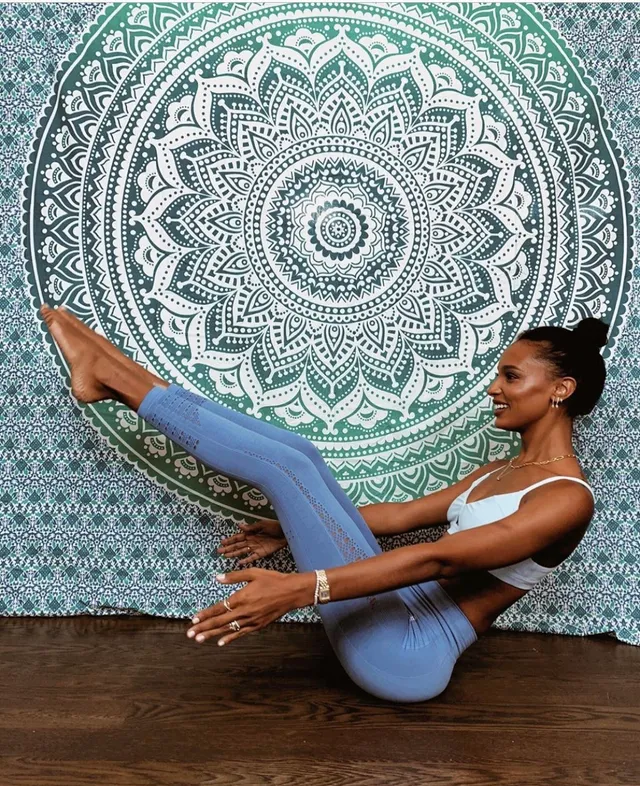 Jasmine Tookes balancing barefoot during an exercise portrait against a patterned backdrop.
