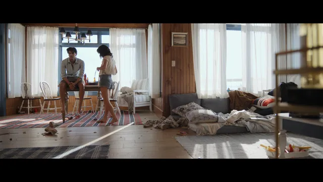 Emily Alyn Lind walking barefoot indoors beside a fellow performer.
