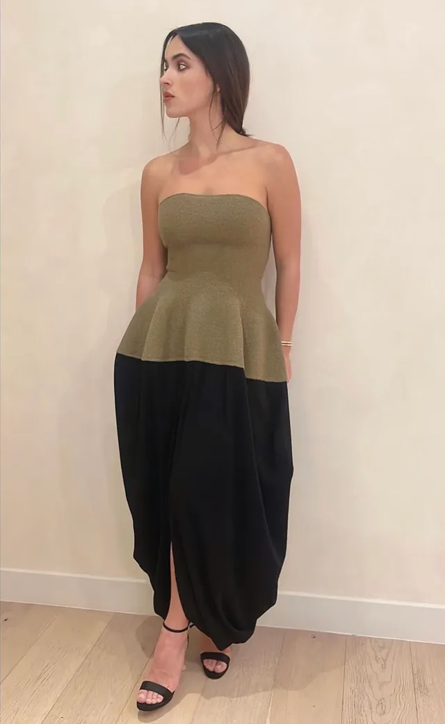 Adria Arjona wearing an olive top, black trousers and black heels.