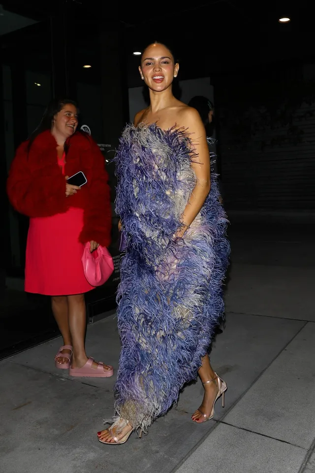Eiza González walking in a purple textured gown and metallic heels.