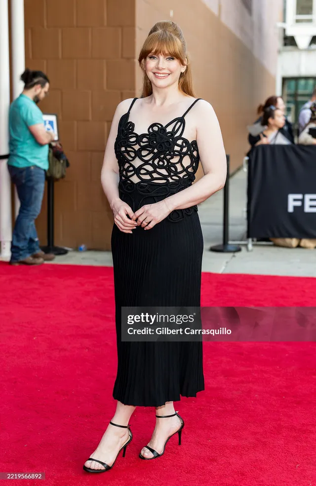 Bryce Dallas Howard posing at a film festival in a black dress.