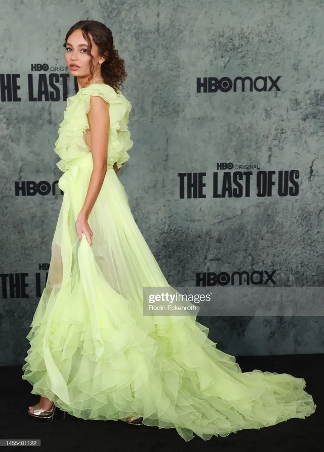 Nico Parker posing on a premiere carpet in a long green gown.