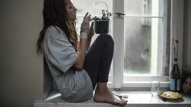 Teresa Palmer sitting beside a window for a portrait.