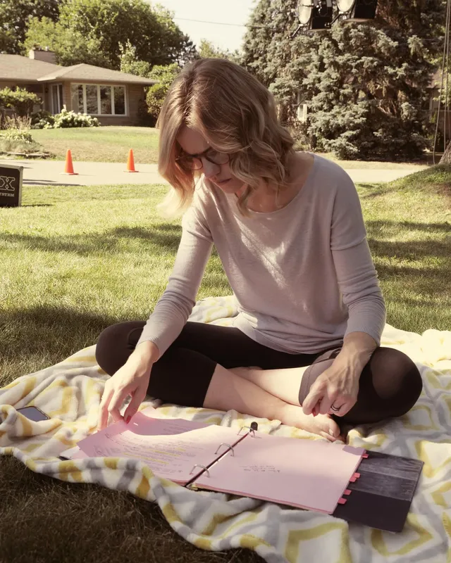 Willa Fitzgerald sitting barefoot on a picnic blanket.