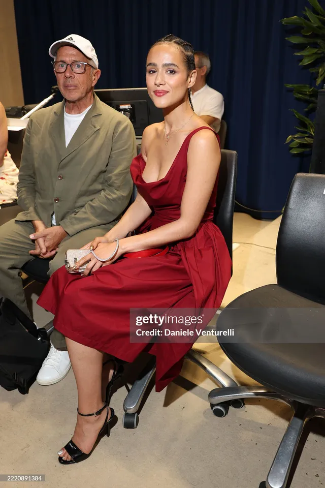Nathalie Emmanuel sitting beside a guest at a festival.