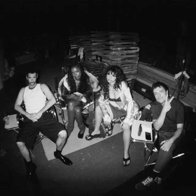Odessa A'zion sitting with friends in a monochrome photograph.