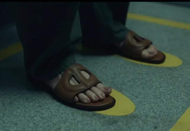 Olivia Munn wearing brown open-toe slides in a film scene.