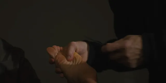 Zoe Saldaña having a foot examined in a screen scene.