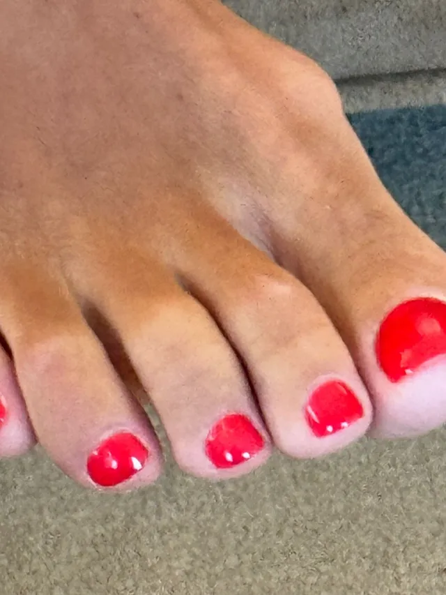 Lily Allen showing a red pedicure in a close-up.