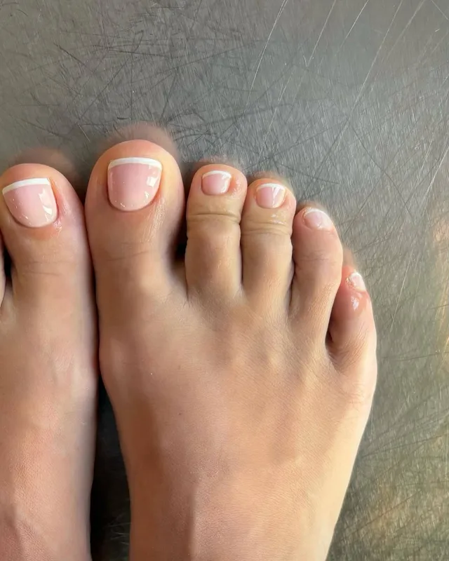 Lily Allen showing a pale pedicure in a close-up.