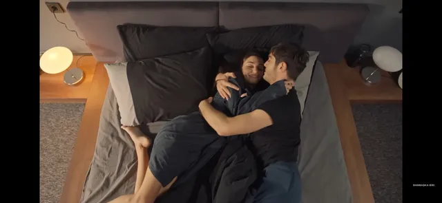 Hande Erçel reclining barefoot on a bed.