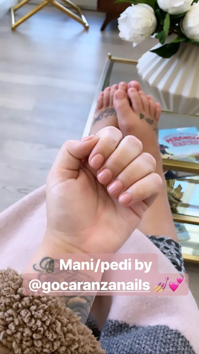 Demi Lovato showing bare toes beneath a hand with pale nail polish.