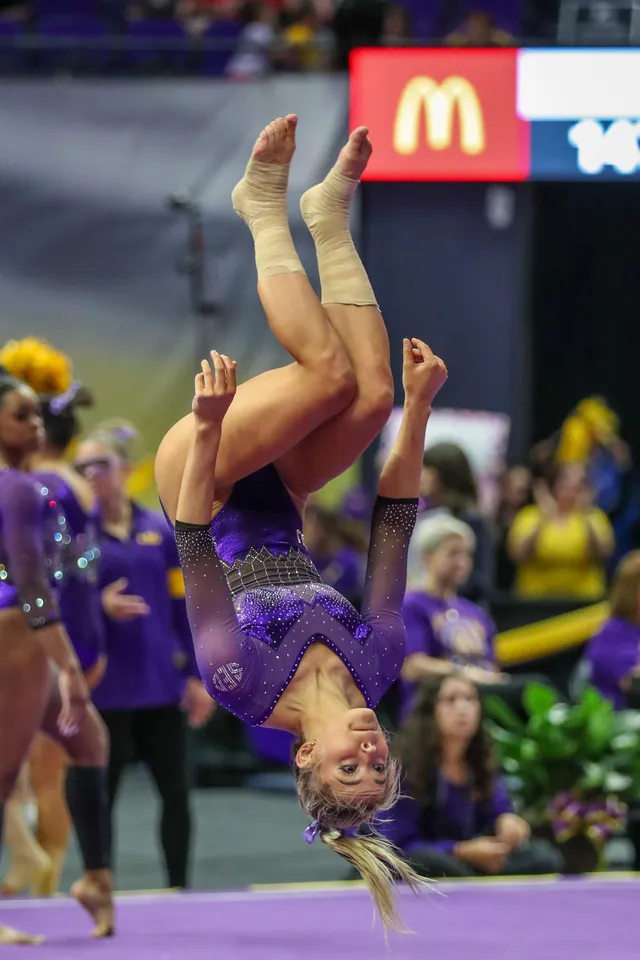 Olivia Dunne: performing a barefoot tumbling skill at a gymnastics competition.