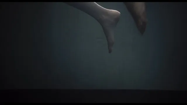 Léa Seydoux floating in a dimly lit underwater screen scene.