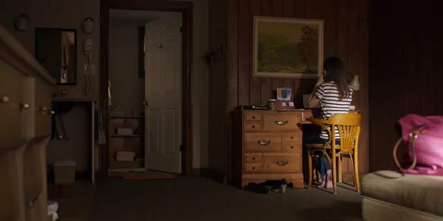 Anna Kendrick standing in a kitchen during an indoor scene.