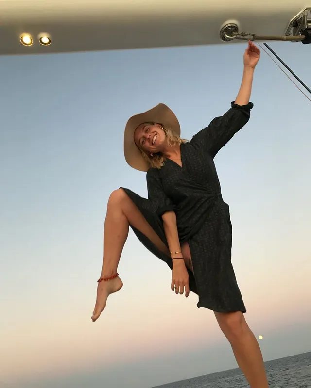 Alice Eve balancing on one leg outdoors.