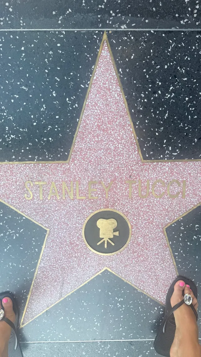 Addison Rae wearing a flip-flop beside a pavement star.