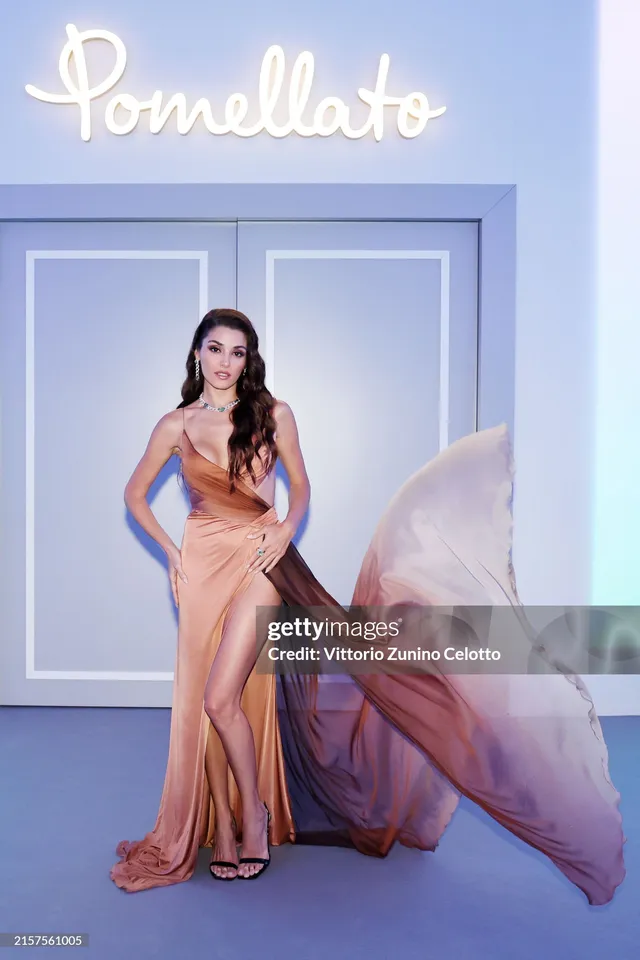 Hande Erçel wearing a peach gown and white heels.