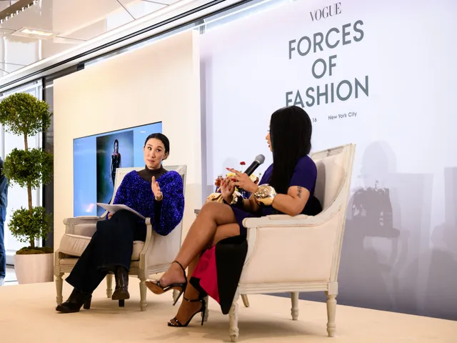 Nicki Minaj sitting on stage during an interview in strappy heels.