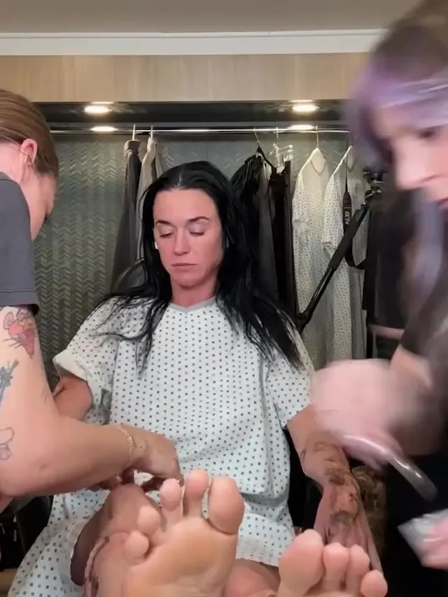 Katy Perry showing bare soles while sitting in a makeup chair.