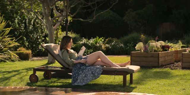 Victoria Pedretti reclining on an outdoor lounger during a screen scene.