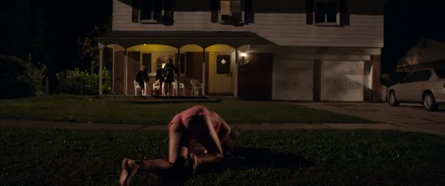 Maika Monroe crouching barefoot outdoors in a scene.