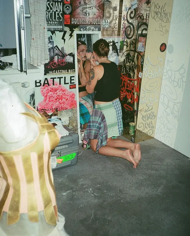 Tove Lo kneeling indoors with bare soles visible.