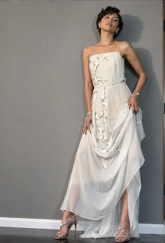 Zendaya posing in a white dress.