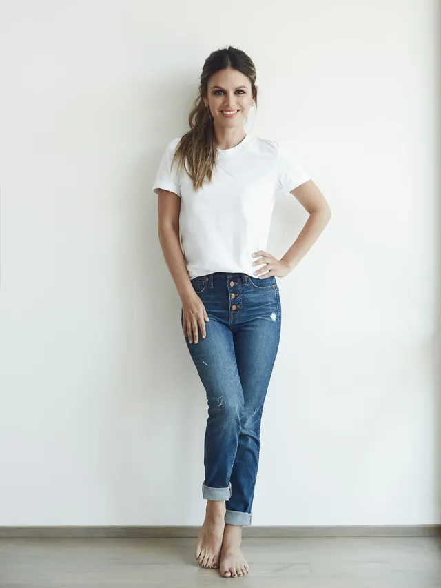 Rachel Bilson standing in jeans and a white top during a portrait shoot.