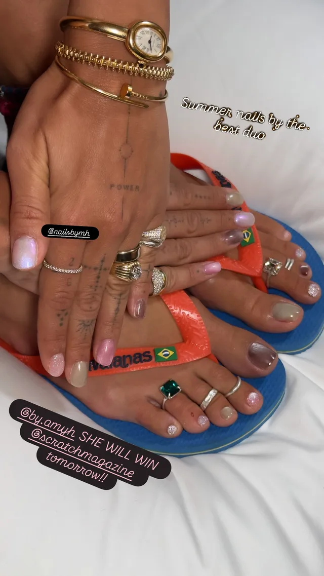 Rita Ora showing colourful flip-flops with rings and a manicure.
