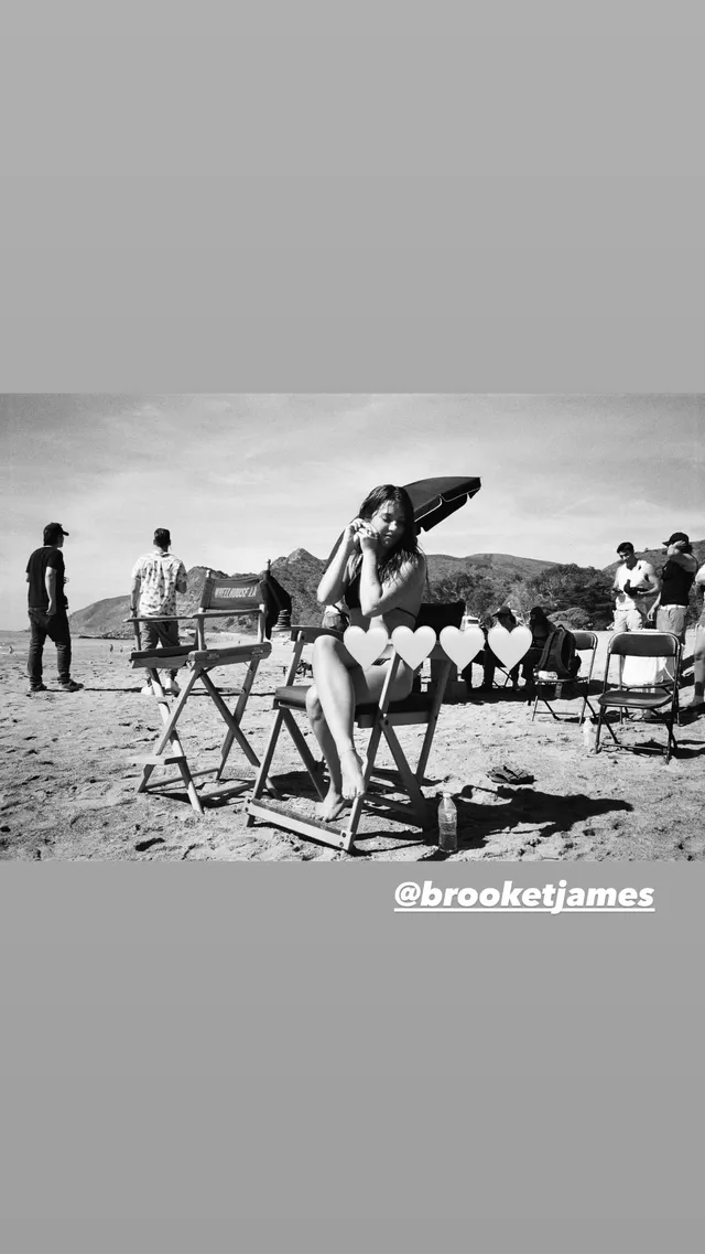 Mackenzie Ziegler sitting with a group during a beach shoot.