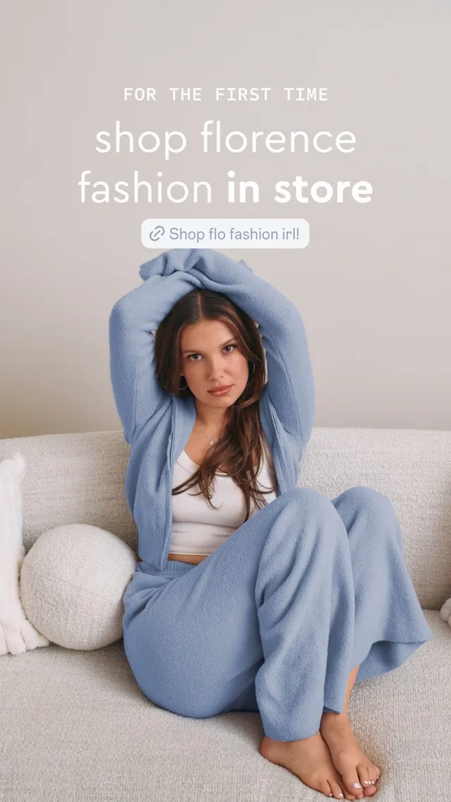 Millie Bobby Brown sitting on a sofa in a blue outfit.