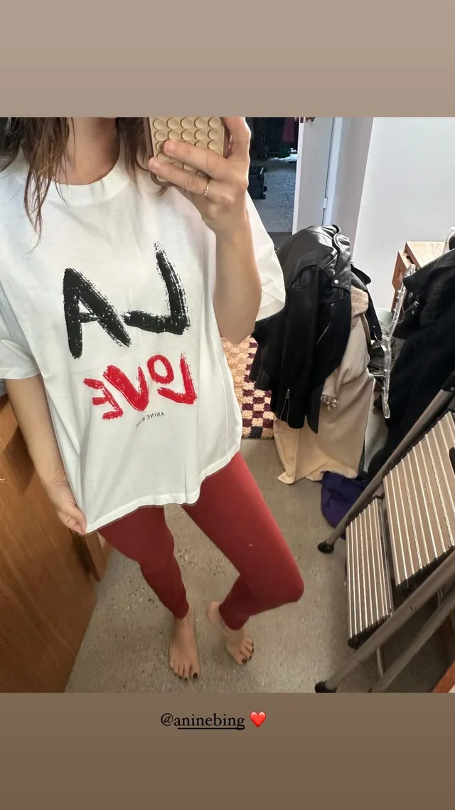 Rachel Bilson taking a casual mirror portrait in a white T-shirt.