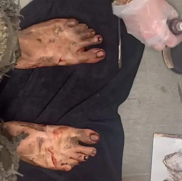 Freya Allan showing mud-covered bare feet during film makeup preparation.