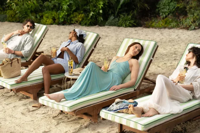Sophie Turner a pale blue dress while reclining on a sunbed.