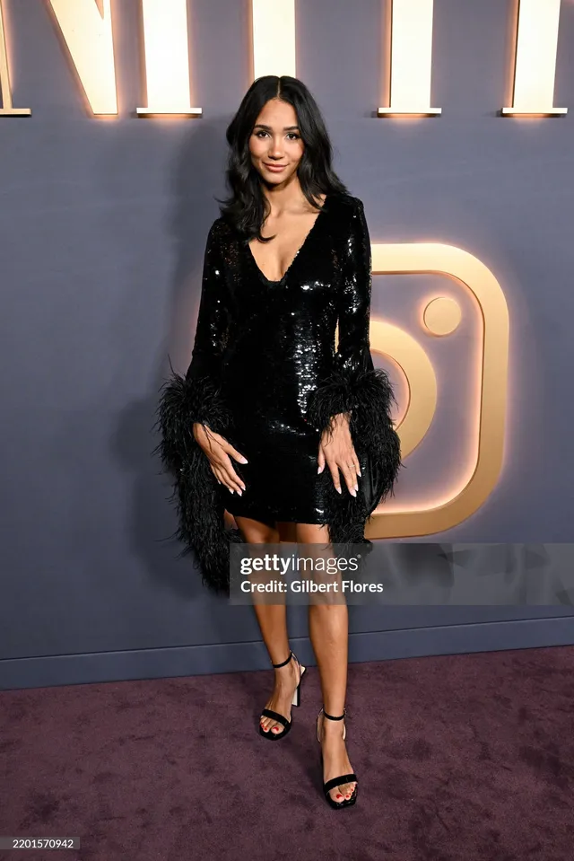 Greta Onieogou wearing a short black dress and heels at an event.
