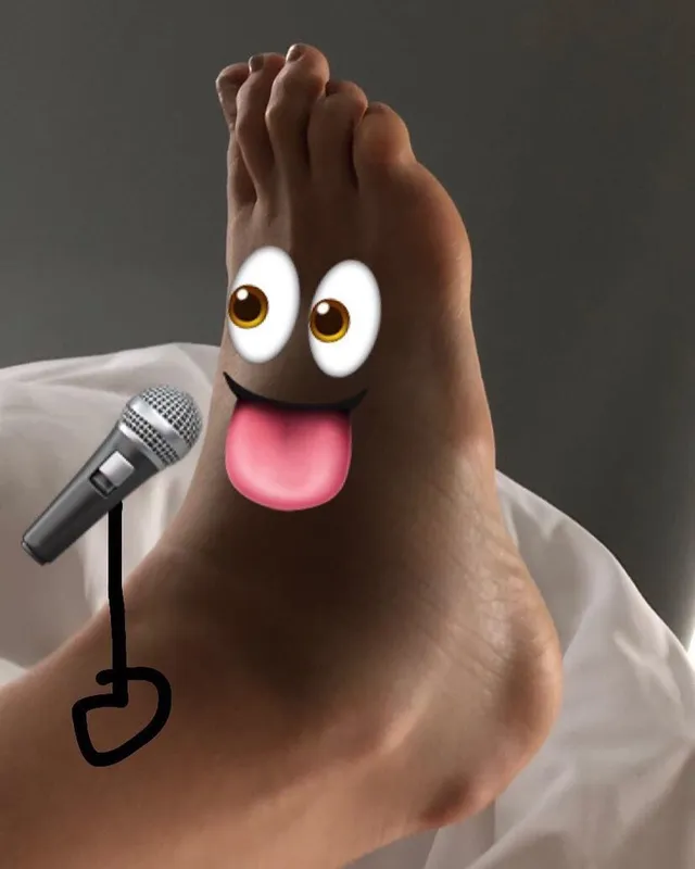 Tove Lo showing a bare sole with playful graphic stickers.