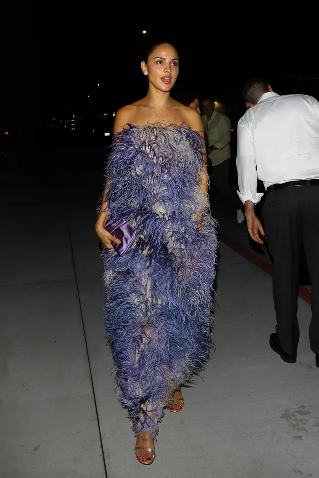 Eiza González walking in a purple textured gown and metallic heels.