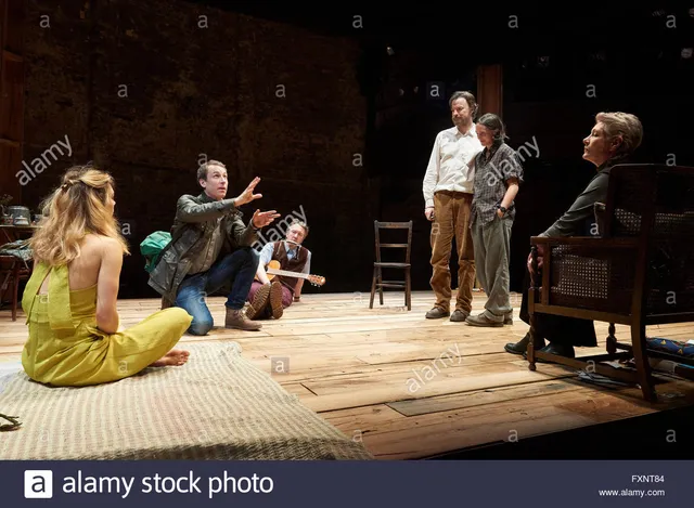 Vanessa Kirby seated on a theatre stage beside fellow performers.